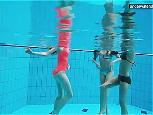 three nude femmes have fun underwater
